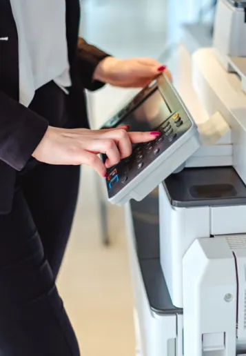 Woman pressing a button on an office copier
