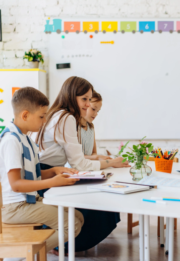 Teacher and young learners working together at a classroom table