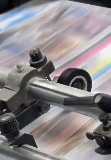 Close-up of printing press rollers running full-colour print