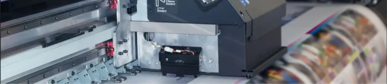 Close-up of a production printer outputting full-colour prints